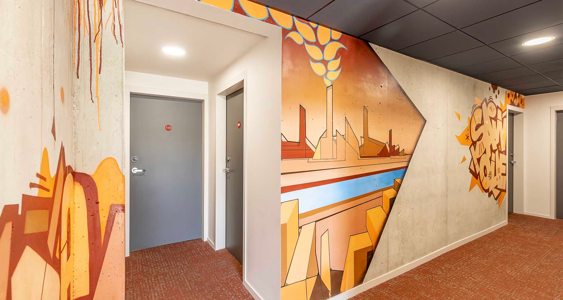 Couloir 11Bauer · fresque orange sur béton, skyline industrielle de Saint-Ouen